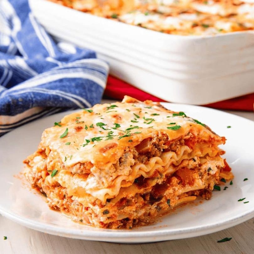 A generous slice of Mikes Pizza Doral's lasagna, rich with layers of pasta, meat sauce, and melted cheese.
